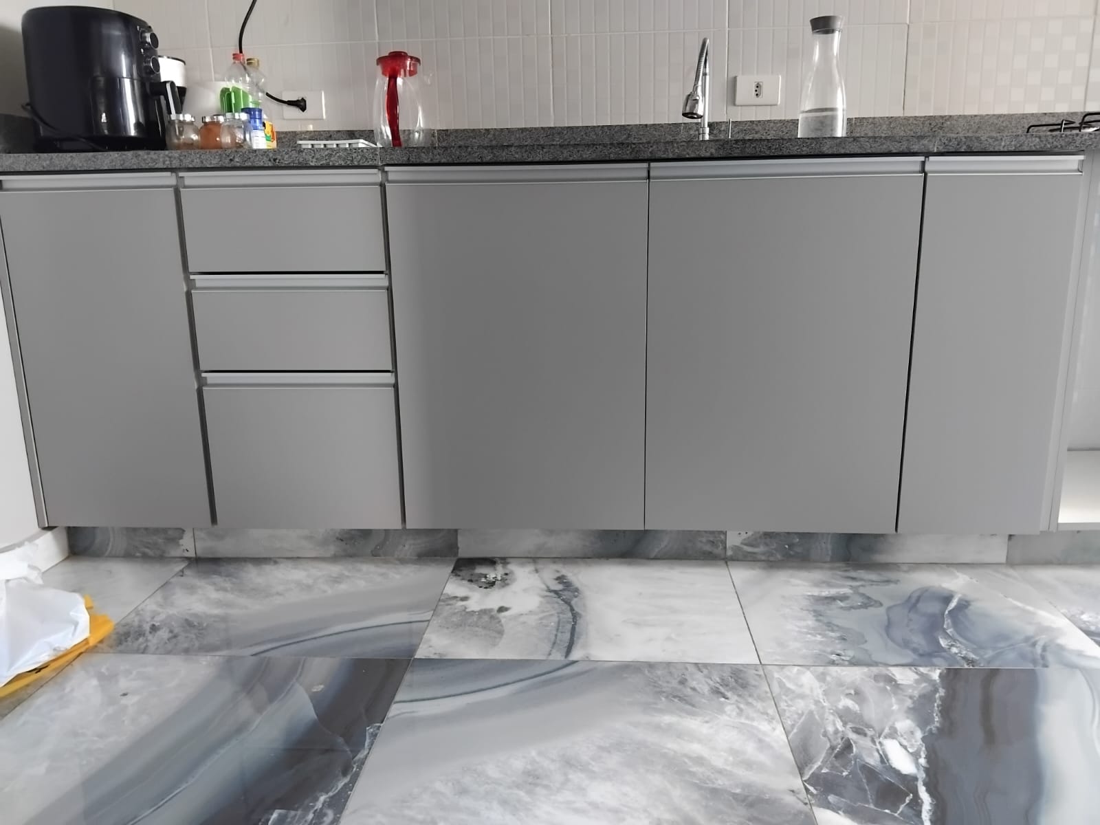 Cozinha planejada com armários cinza e bancada de granito